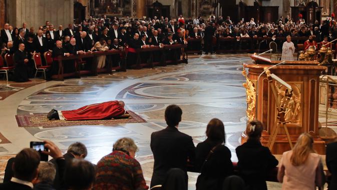 Paus Fransiskus berdoa sambil berbaring di lantai dalam prosesi Jumat Agung memperingati penyiksaan Yesus sebelum disalibkan di Basilika Santo Petrus, Vatikan, Jumat (19/4). (AP Photo/Alessandra Tarantino)