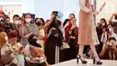 Pengunjung mengabadikan model dengan busana kain serat alami pada Ecoprint Fashion Week 2022 di The Plaza Semanggi, Jakarta, Rabu (06/4/2022). Kegiatan yang berkontribusi terhadap kebangkitan perekonomian merupakan bentuk komitmen LMI pada budaya dengan konsep zero-waste. (Liputan6.com/Fery Pradolo)