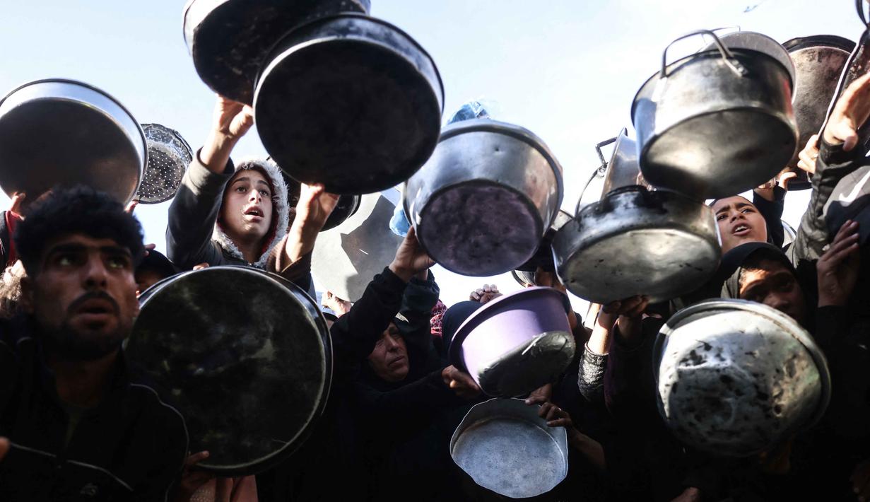 Organisasi kemanusiaan seperti World Central Kitchen (WCK) melaporkan stok makanan di gudang akan habis dalam hitungan hari. Tampak dalam foto, warga Palestina yang mengungsi berebut untuk makanan di Khan Younis, selatan Jalur Gaza pada Jumat 6 Maret 2026. (Bashar Taleb/AFP)