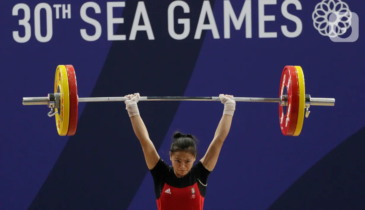 Lifter Windy Aisyah melakukan angkatan saat SEA Games 2019 cabang angkat besi nomor 49 kg di Stadion Rizal Memorial, Manila, Minggu (1/12/2019). Windy Aisyah meraih emas dengan total angkatan 104 kg. (Bola.com/M Iqbal Ichsan)