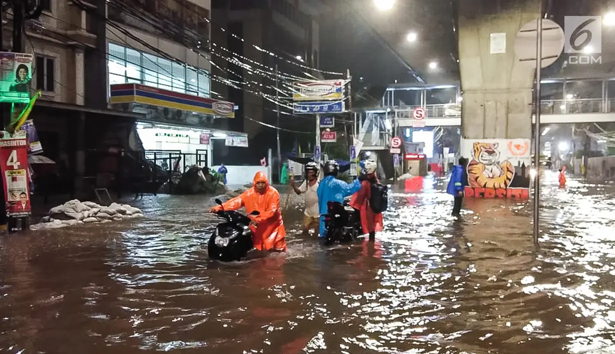 Pengendara mendorong motor saat banjir menggenangi kawasan Simpang Seskoal, Kebayoran Lama, Jakarta, Sabtu malam (16/2). Banjir setinggi 50cm - 1 meter hanya bisa dilalui bus atau kendaraan berukuran besar. (Liputan6.com/Septian)