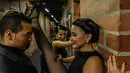 Penari melakukan pemanasan di belakang panggun sebelum tampil dalam Turnamen Menari Tango di Festival Tango Internasional XIII di Medellin, Kolombia (18/6/2019). Festival Tango ini berlangsung dari 16 sampai 24 Juni 2019. (AFP Photo/Joaquin Sarmiento)