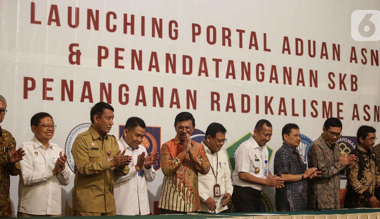 Menkominfo Johnny G. Plate (kelima kiri) bersama sebelas Kementerian dan lembaga negara  usai penandatangan kerja sama pembuatan portal aduan untuk aparatur sipil negara (ASN), Jakarta, Selasa (12/11/2019). Portal ini bisa melaporkan ASN yang diduga terpapar radikalisme. (Liputan6.com/Faizal Fanani)