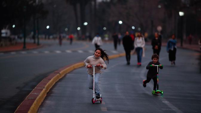 Anak-anak bermain skuter saat pembukaan kembali area Buenos Aires di Argentina, Senin (20/7/2020). Tempat-tempat yang biasa dikunjungi warga mulai dibuka setelah pemerintah Argentina mulai melonggarkan pemberlakuan pembatasan untuk pencegahan penyebaran corona COVID-19. (AP Photo/Natacha Pisarenko)