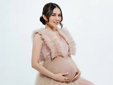 Pakai gaun sleeveless warna cokelat berbahan tile, Vicy Melanie tampil anggun dan terlihat seperti putri. Rambut yang disanggul dengan juntaian poni di samping kiri dan kanannya, aura Vicy Melanie kian terpancar di pemotretan maternity shootnya ini. Wajah cantik artis berusia 35 tahun ini dipoles oleh MUA Annesya. Tonjolkan highlighter blush, Vicy Melanie memukau. (Liputan6.com/IG/@vicymelanie)