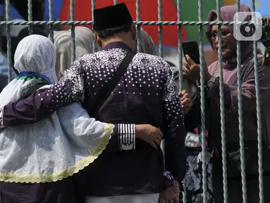 Keluarga dan kerabat mengambil gambar jamaah haji kloter pertama embarkasi Jakarta usai tiba di asrama haji Pondok Gede, Jakarta, Sabtu (11/5/2024). (merdeka.com/Imam Buhori)