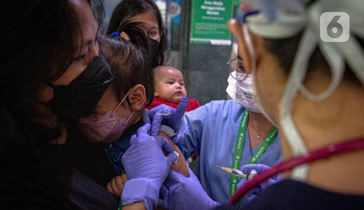 Petugas memeriksa kesehatan serta imunisasi pasien anak di RSIA Bunda, Jakarta, Jumat (18/3/2022). Pemeriksaan dilakukan drive thru guna memberi rasa aman orangtua, khususnya ibu yang ingin melaksanakan imunisasi serta pemeriksaan nonpenyakit di tengah pandemi COVID-19. (Liputan6.com/Faizal Fanani)