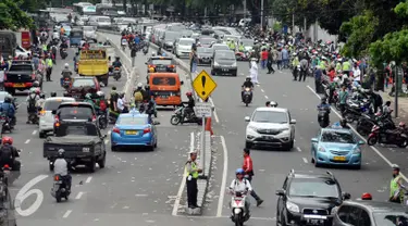 Polisi mengatur lalu lintas di Jalan Medan Merdeka Timur usai ribuan massa ormas melakukan unjuk rasa di Bareskrim Polri, Gedung KKP Jakarta, Jumat (14/10). Dalam aksinya, massa meminta Basuki Tjahaja Purnama ditahan. (Liputan6.com/Helmi Fithriansyah)