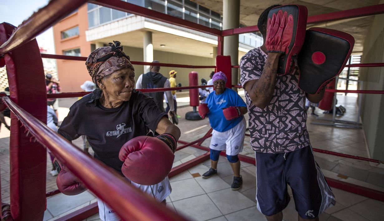 Para nenek berlatih tinju pada Boxing Gogos di Cosmo City, Johannesburg, Selasa (19/9/2017). Berkat latihan rutin yang dipimpin Claude Maphosa ini para lansia berhasil sembuh dari penyakit dan hidup lebih sehat. (AFP/Gulshan Khan) 