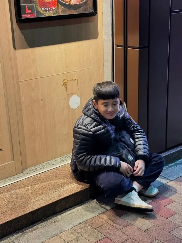 Ekspresi Rafathar duduk di pinggir jalan Jepang. (credit: instagram.com/raffinagita1717)