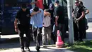 Dua dari 8 perwira militer pendukung kudeta Turki menutupi wajahnya, di Alexandroupoli, utara Yunani, Minggu (17/7). 8 pria yang terbang dengan helikopter militer Turki itu ditahan petugas keamanan Yunani karena masuk secara ilegal. (Sakis MITROLIDIS/AFP)