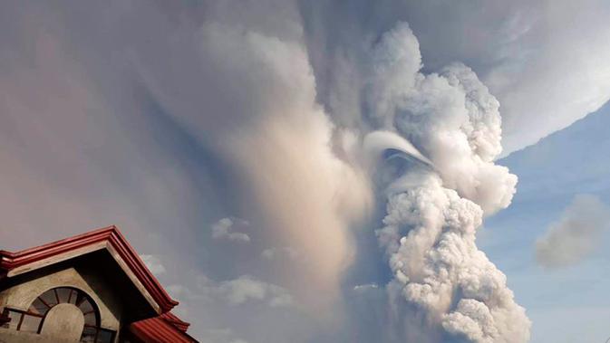 Gunung berapi Taal memuntahkan abu dan asap saat erupsi di Tagaytay, Provinsi Cavite, Filipina, Minggu (12/1/2020). Para pejabat setempat akan memerintahkan evakuasi orang-orang yang tinggal di pulau lain di dekatnya jika situasinya memburuk. (Jogs Danao/AP Photo)