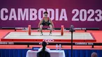 Atlet Indonesia Muhammad Husni bertanding di nomor angkat besi 55 kilogram putra pada Pesta Olahraga Asia Tenggara (SEA Games) ke-32 di Phnom Penh pada 13 Mei 2023. (AFP/Mohd Rasfan)