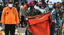Prajurit TNI membawa kantong jenazah korban pesawat Sriwijaya Air PK-CLC nomor penerbangan SJ-182  yang jatuh di perairan Pulau Seribu, di Dermaga JICT, Jakarta, Selasa (12/1/2021). (Liputan6.com/Johan Tallo)