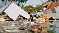 Seorang pria memeriksa kerusakan akibat gempa dan tsunami di Palu, Sulawesi Tengah , Sabtu (29/9). Gelombang tsunami setinggi 1,5 meter yang menerjang Palu terjadi setelah gempa bumi mengguncang Palu dan Donggala. (AP Photo/Rifki)