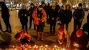 Sejumlah orang menyalakan lilin di depan foto jurnalis investigasi Slovakia Jan Kuciak di Wenceslas Square di Praha (26/2). Mereka berkumpul sambil menyalakan lilin untuk memberi penghormatan kepada Jan Kuciak. (AFP Photo/Michal Cizek)