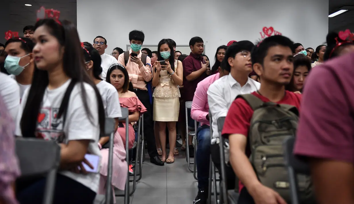 Sejumlah pasangan menunggu untuk mendaftarkan surat nikah mereka pada Hari Valentine di Bang Rak atau Distrik Cinta di Bangkok, Thailand, Jumat (14/2/2020). Banyak pasangan menikah di Distrik Cinta karena mereka percaya akan membawa keberuntungan dan cinta yang tahan lama. (Lillian SUWANRUMPHA/AFP)