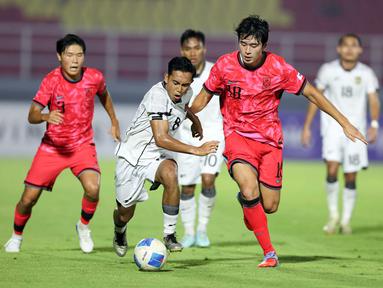 Pemain Timnas Indonesia U-23, Muhammad Rayhan Hannan (tengah) berebut bola dengan Jeong Jaesang (Korea Selatan) pada laga Kualifikasi Piala Asia U-23 2026 Grup J yang digelar di Stadion Gelora Deltra, Sidoarjo, Jawa Timur, Selasa (9/9/2025) malam WIB. (Bola.com/Abdul Aziz)