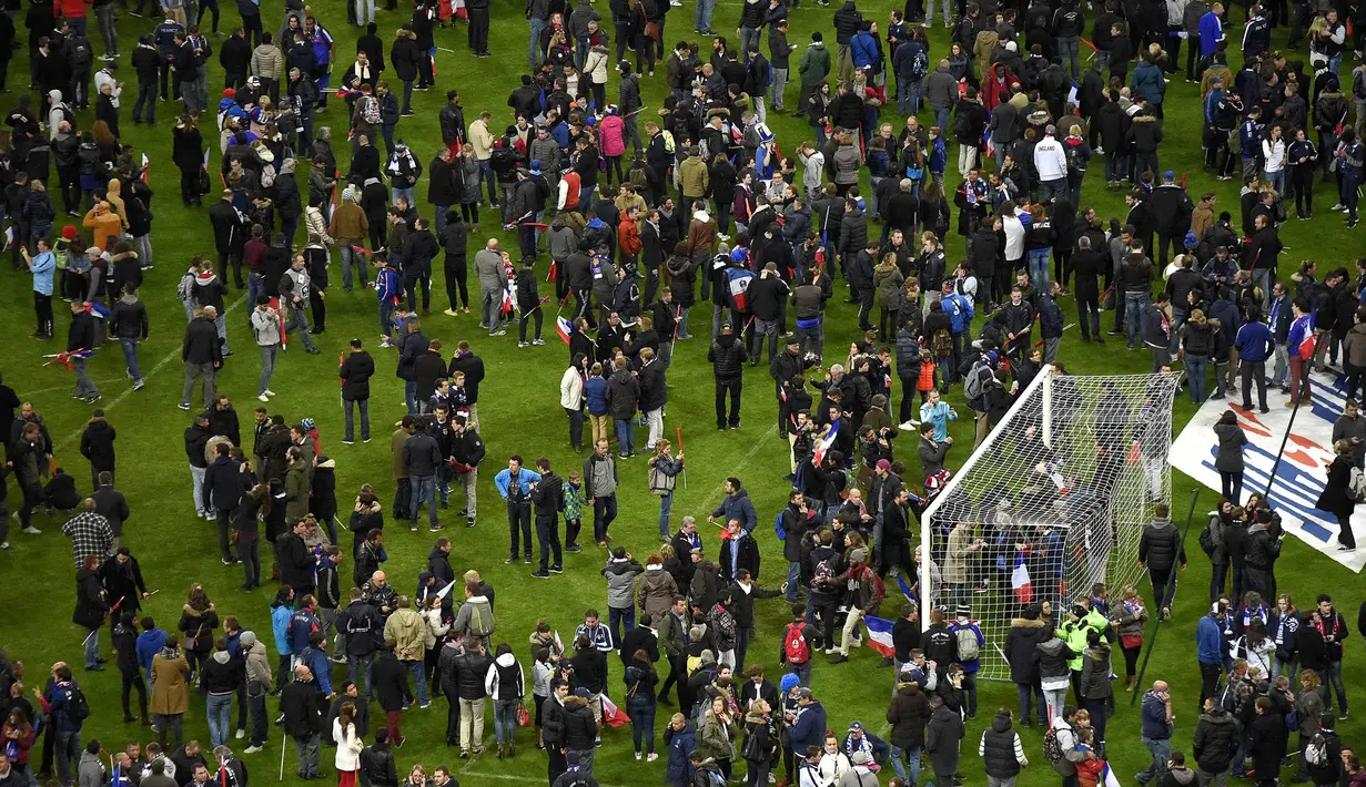 Pihak keamanan menahan penonton untuk tetap berada di stadion akibat tindak terorrisme yang terjadi di sekitar Stadion Stade de France, Prancis, Sabtu (13/11/2015). (AFP Photo/Franck Fife)