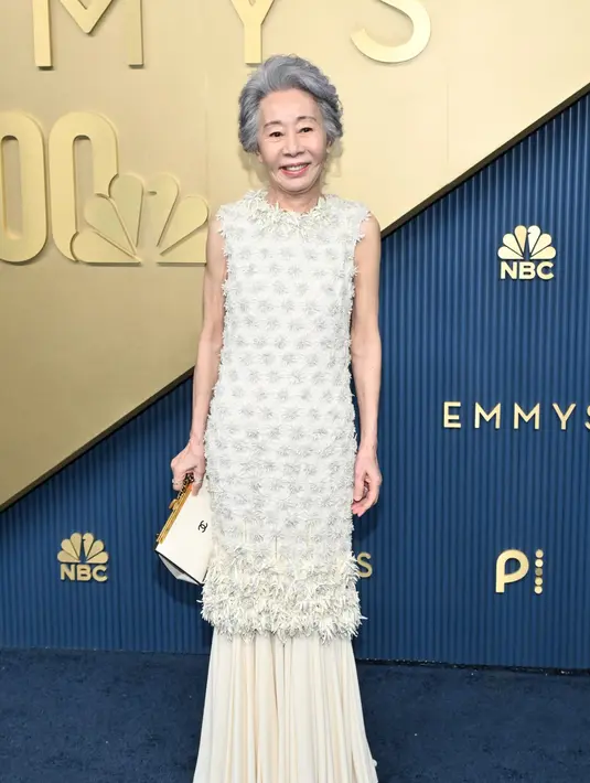 Youn Yuh-Jung mengenakan gaun silk putih yang disulam motif bunga bernuansa alabaster. Penampilannya dilengkapi sepatu dari Chanel yang menyempurnakan gaya anggun namun tetap effortless [dok. Chanel]