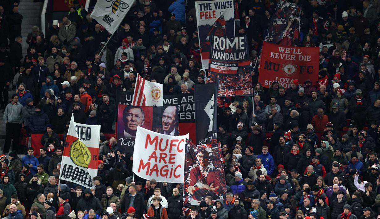 Tanpa kawalan sejumlah pemain inti, Setan Merah berhasil meredam tekanan Newcastle United. Tampak dalam foto, para penggemar United mengibarkan bendera menjelang dimulainya pertandingan sepak bola Liga Premier Inggris antara Manchester United dan Newcastle United di di Stadion Old Trafford, pada 26 Desember 2025 waktu setempat atau Sabtu (27/12/2025) dini hari WIB. (Darren Staples/AFP)