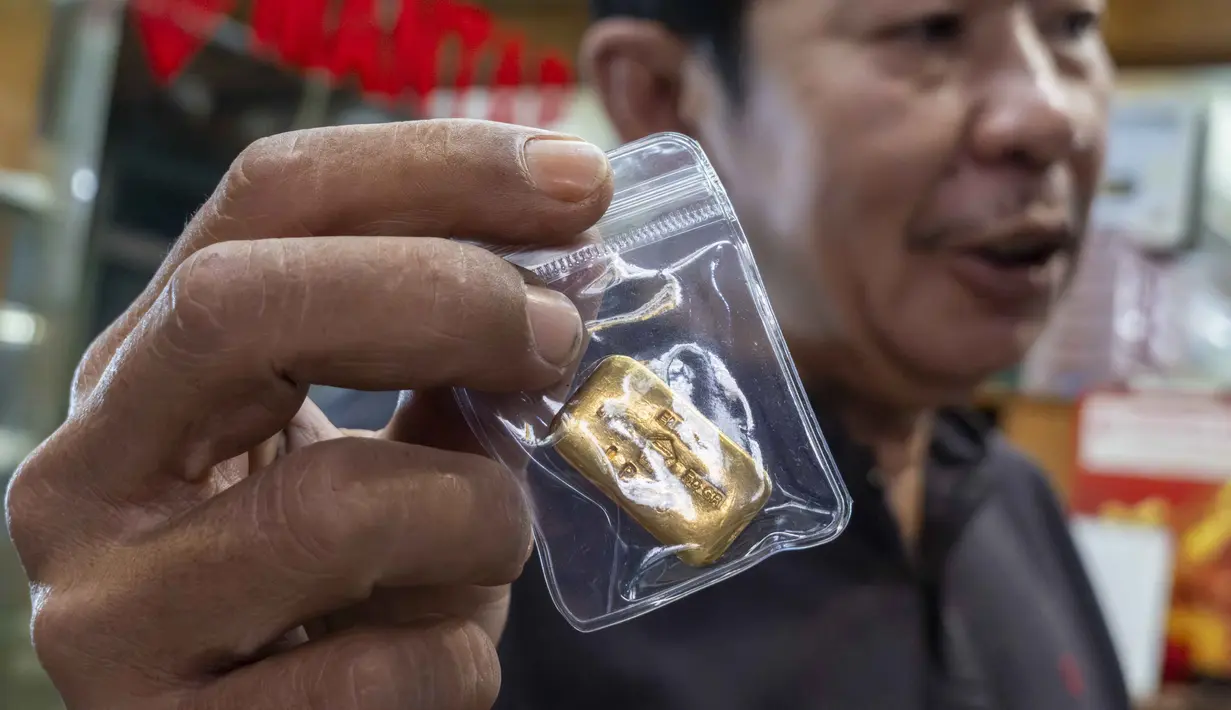 Seorang pedagang emas menunjukkan batangan emas kepada pelanggan di sebuah toko emas di Jakarta pada Jumat 29 Mei 2026. (BAY ISMOYO/AFP)