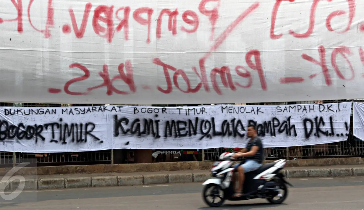 Warga melintas depan spanduk penolakan sampah DKI Jakarta di Jalan Raya Narogong, Bogor Timur, Jawa Barat, Rabu (4/11/2015). Warga menolak truk sampah melintas sampai Pemprov DKI Jakarta memberikan jaminan. (Liputan6.com/Immanuel Antonius)