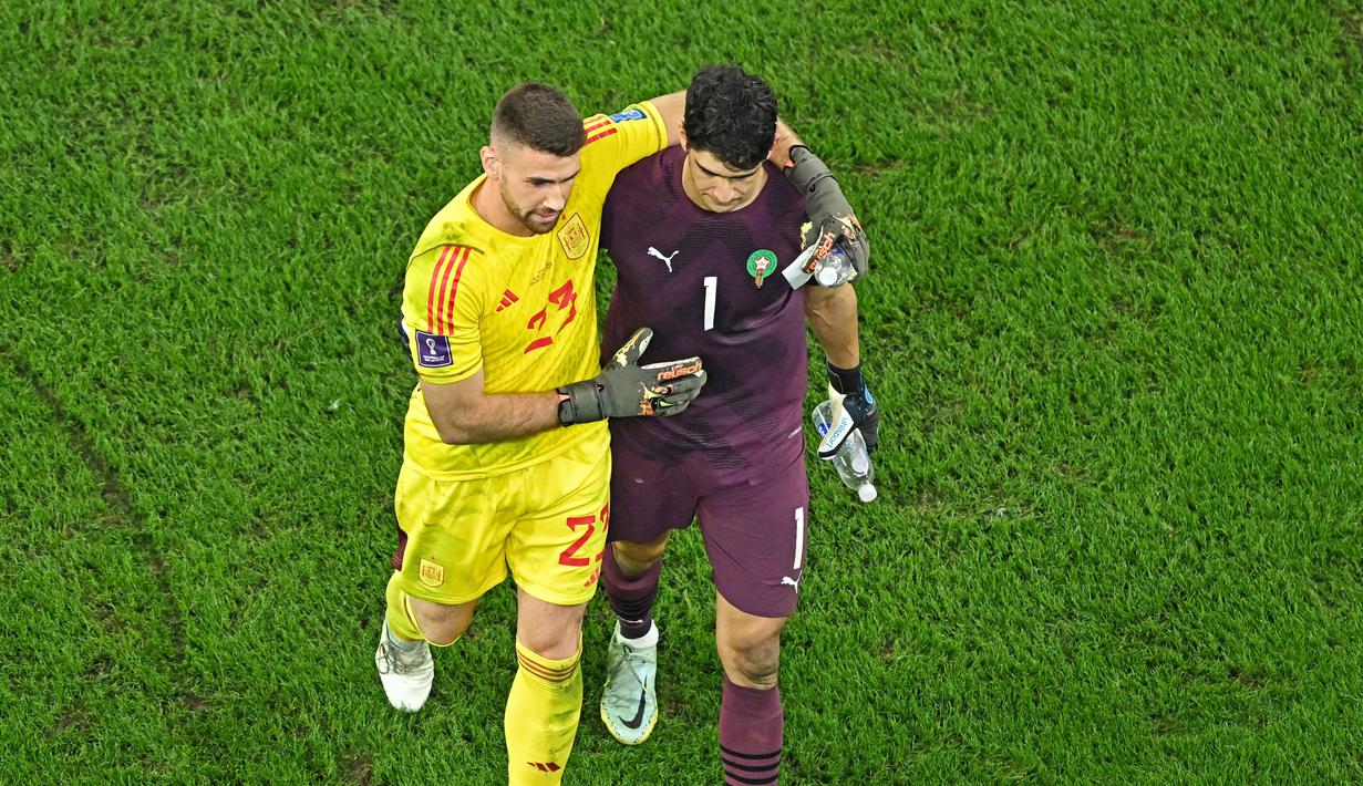 Kiper Spanyol, Unai Simon sempat saling berbincang dengan kiper Maroko, Yassine Bounou, sebelum babak adu penalti pada laga 16 besar Piala Dunia 2022 di Stadion Education City, Selasa (6/12/2022). (AFP/Manan Vatsyayana)