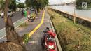 Pengendara sepeda motor memarkirkan kendaraannya di trotoar Danau Sunter, Jakarta, Jumat (19/1). Hal ini dikerenakan kurangnya kesadaran warga yang akhirnya merugikan pengguna trotoar semestinya, yaitu pejalan kaki. (Liputan6.com/Immanuel Antonius)