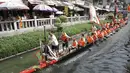 Peserta perahu naga dari desa Panting mendayung di sepanjang kanal di kawasan bersejarah Teluk Lychee di Guangzhou di Provinsi Guangdong, China selatan, Jumat, 3 Juni 2022. Perlombaan perahu naga kembali digelar di beberapa bagian China untuk pertama kalinya sejak merebaknya pandemi pada akhir 2019, saat pembatasan dicabut bersama dengan penurunan besar  kasus COVID-19. (AP Photo/Caroline Chen)