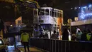 Personel layanan darurat mengamati evakuasi sebuah trem double-decker yang terbalik di jalan utama di Hong Kong, Kamis (6/4). Belum jelas penyebab kecelakaan, namun kemungkinan akibat pengemudi gagal mengendalikan kendaraan tersebut. (ANTHONY WALLACE/AFP)