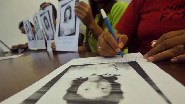 Seorang aktivis menuliskan pesan di foto Marsinah saat konferensi pers