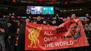 Para suporter Liverpool membentangkan banner sambil bernyanyi setelah laga final Carabao Cup 2023/2024 di Stadion Wembley, Inggris, Minggu (25/02/2024). The Reds menang atas Chelsea dengan skor 1-0 melalui gol Virgil Van Dijk pada menit ke-118. (AFP/Adrian Dennis)