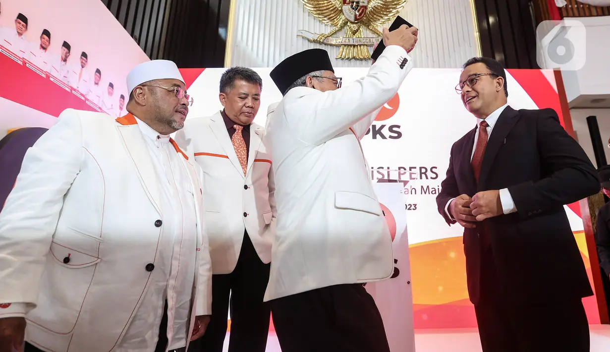 Presiden PKS Ahmad Syaikhu menyematkan peci kepada mantan Gubernur DKI Jakarta Anies Rasyid Baswedan (kanan) sebagai tanda dukungan sebagai bakal calon presiden 2024-2029 usai pembacaan hasil keputusan Musyawarah Majelis Syuro VIII PKS di Jakarta, Kamis (23/2/2023). PKS secara resmi mendukung Anies Baswedan sebagai bakal calon presiden tahun 2024-2029. (Liputan6.com/Johan Tallo)