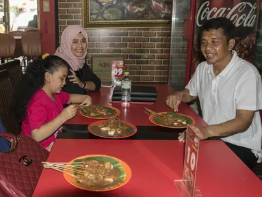 Pelatih Mitra Kukar, Jafri Sastra, didampingi istri dan kedua anaknya makan sate padang di kawasan Jakarta Selatan, Sabtu (23/1/2016). (Bola.cm/Vitalis Yogi Trisna)