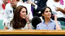 Duchess of Cambridge Kate Middleton dan Duchess of Sussex Meghan Markle berbincang saat menyaksikan pertandingan tenis dalam Kejuaraan Wimbledon di London, Inggris, (14/7). (AP Photo/Nic Bothma)