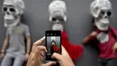 Sejumlah orang berfoto dengan replika tengkorak saat pameran dan kontes di perayaan Hari Kematian di Mexico City (1/11). Perayaan ini menandai bulan kesembilan dari kalender matahari suku Aztec. (AFP Photo/Yuri Cortez)