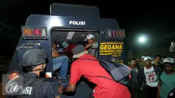 Seorang personil Brimob mengawal skuat PBFC yang akan masuk kedalam kendaraan taktis usai laga melawan Persib di Stadion Si Jalak Harupat, Bandung, Sabtu (26/9/2015). PBFC kalah 1-2 dari Persib. (Liputan6.com/Helmi Fithriansyah)