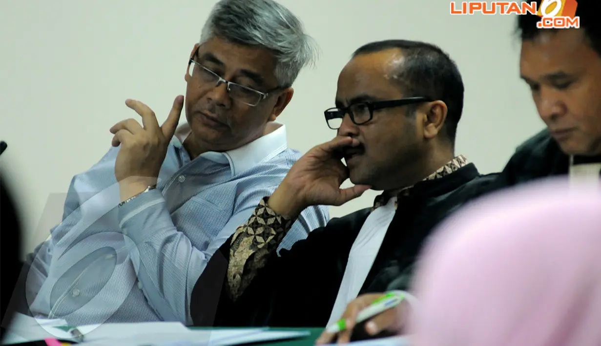 Akil Mochtar tampak berdiskusi dengan penasehat hukumnya di Pengadilan Tipikor Jakarta, Kamis (10/4/2014) (Liputan6.com/Faisal R Syam).