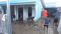 Warga penghuni hunian penyintas Gempa Palu membersihkan rumah mereka usai banjir, Minggu (31/7/2022). (Foto: Heri Susanto/ Liputan6.com).