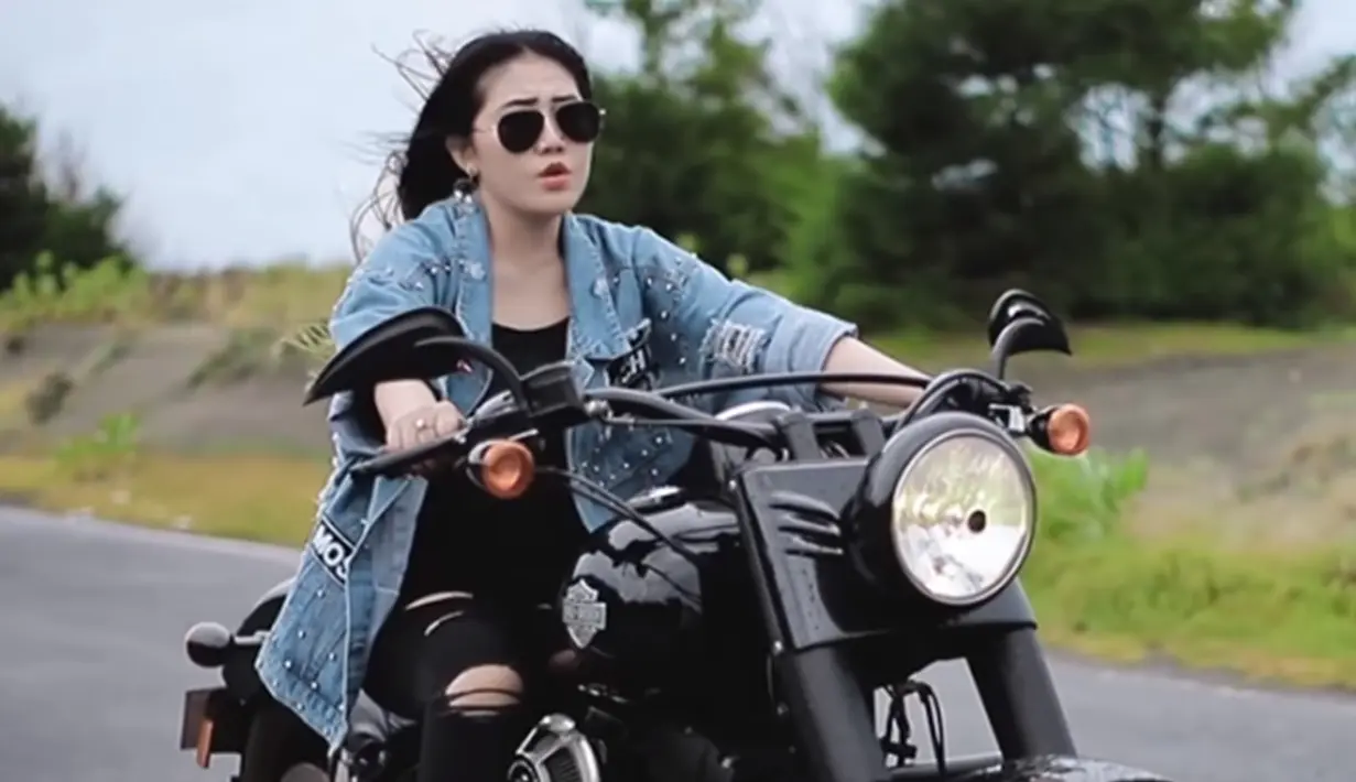 Dengan outfit hitam dibalut outer denim, gaya Via Vallen saat naik motor gede atau mode sukses bikin penggemar terpesona. (Liputan6.com/YouTube/Via Vallen)