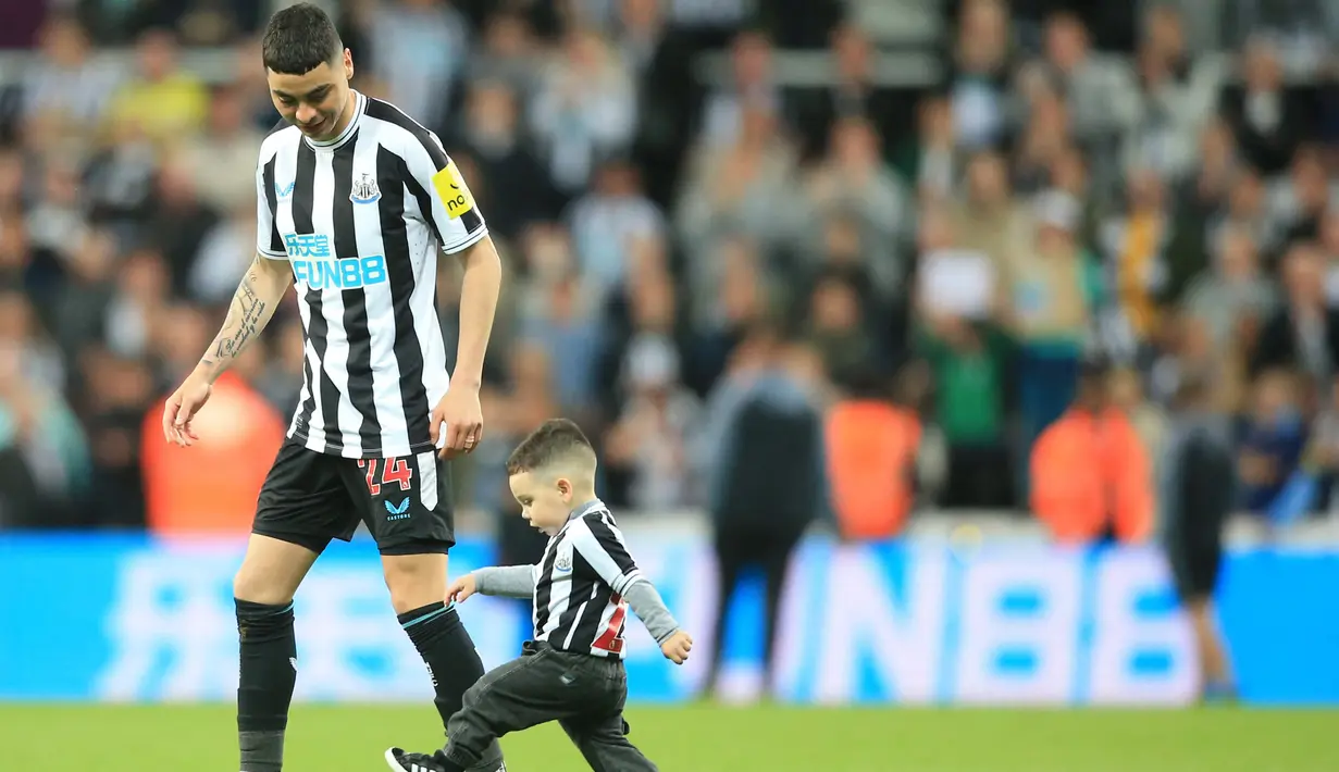 Pemain Newcastle United, Miguel Almiron, bermain dengan anaknya setelah laga melawan Leicester City pada pekan ke-37 Premier League 2022-2023, Selasa (23/5/2023). Hasil imbang melawan Leicester membawa The Magpies lolos ke Liga Champions musim depan. (AFP/Lindsey Parnaby)