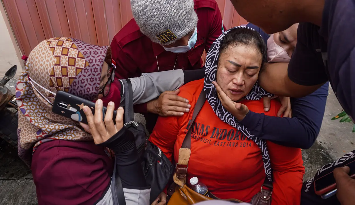 Seorang wanita menangis setelah menerima konfirmasi bahwa anggota keluarganya termasuk dalam korban tewas pada kerusuhan Stadion Kanjuruhan di Rumah Sakit Saiful Anwar, Malang, Jawa Timur, Minggu (2/10/2022). Dari 129 korban tewas, dua di antaranya adalah polisi. (AP Photo/Trisnadi)
