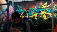 Seniman grafiti menyelesaikan lukisannya selama festival pekan grafiti di Mexico City, Meksiko, Minggu (9/10). Biasanya lewat festival, dapat mengangkat potensi seniman-seniman lokal untuk tampil bersama karya seniman terkenal. (REUTERS/Carlos JASSO)