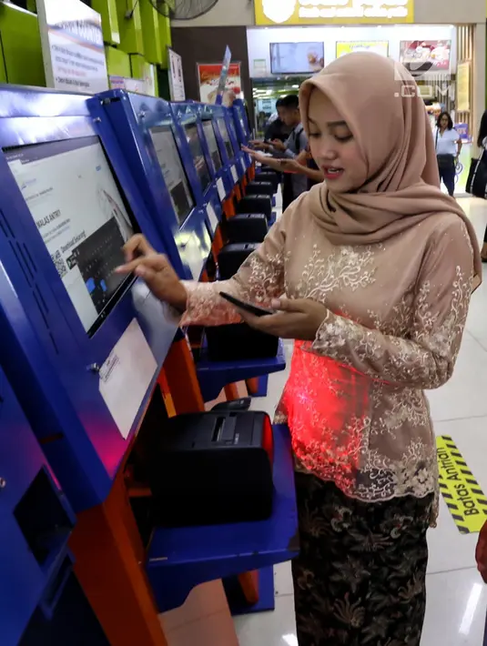 Petugas frontliner berpakaian tradisional saat membantu calon penumpang membeli tiket di Stasiun Gambir, Jakarta, Minggu (21/4). PT KAI Daop 1 Jakarta mewajibkan petugas frontliner wanita dan pria mengenakan kebaya dan batik untuk menyambut Hari Kartini. (Liputan6.com/Johan Tallo)