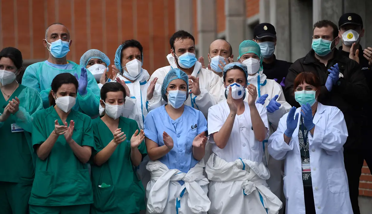 Petugas kesehatan bertepuk tangan untuk mengenang Esteban, perawat yang gugur karena virus corona COVID-19 di Rumah Sakit Severo Ochoa di Leganes, Spanyol, Jumat (10/4/2020). Hingga Minggu (12/4/2020) pagi, total kasus COVID-19 di Spanyol sebanyak 163.027. (Photo by PIERRE-PHILIPPE MARCOU/AFP)