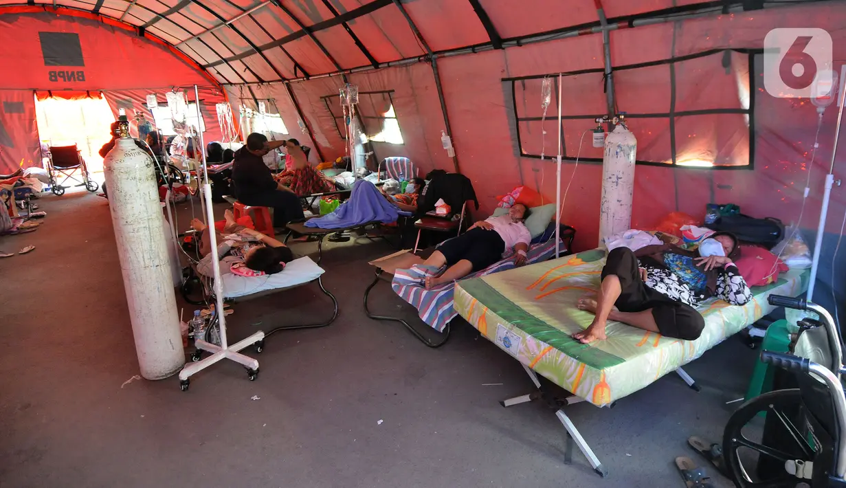 Pasien COVID-19 menjalani perawatan di dalam tenda darurat di RSUD Kota Bekasi, Jawa Barat, Jumat (25/06/2021). Puluhan pasien covid-19 saat ini dirawat dalam tenda darurat karena keterisian tempat tidur yang penuh akibat lonjakan kasus. (merdeka.com/Arie Basuki)