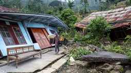 Berdasar data BNPB, hingga Minggu 8 Februari 2026, tercatat ada sekitar 2.453 orang warga Desa Padasari telah meninggalkan rumah mereka ke pengungsian. Tampak dalam foto, seorang pria menyelamatkan barang-barangnya setelah pergerakan tanah melanda permukiman mereka di desa Padasari, Tegal, Jawa Tengah, Senin 9 Februari 2026. (DEVI RAHMAN/AFP)