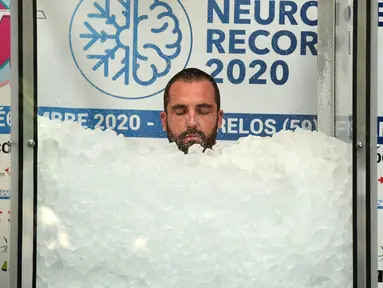 Pria Prancis, Romain Vandendorpe menutup matanya saat mencoba memecahkan rekor dunia di Wattrelos pada 19 Desember 2020. Romain Vandendorpe mencetak rekor dunia dengan duduk di dalam kabin es batu untuk waktu yang lama, demi mengumpulkan dana bagi anak-anak penderita kanker. (FRANCOIS LO PRESTI/AFP)