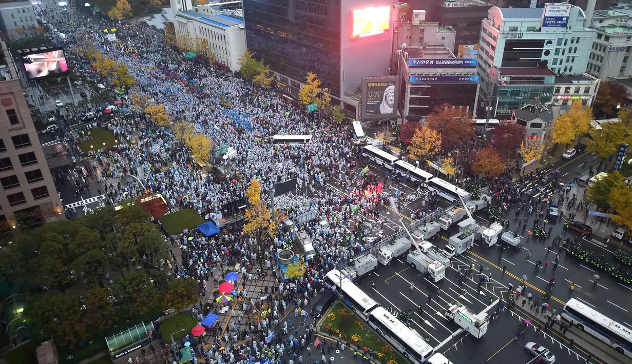 Serikat buruh dan organisasi massa mengadakan aksi besar-besaran di Seoul, Sabtu (14/11/2015). Mereka memprotes rencana pemerintah untuk mengadopsi buku pelajaran sejarah untuk siswa dan langkah-langkah mereformasi tenaga kerja. (AFP Photo/Jung Yeon)